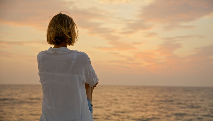 A woman watching the sunset on a beach A woman watching the sunset on a beach